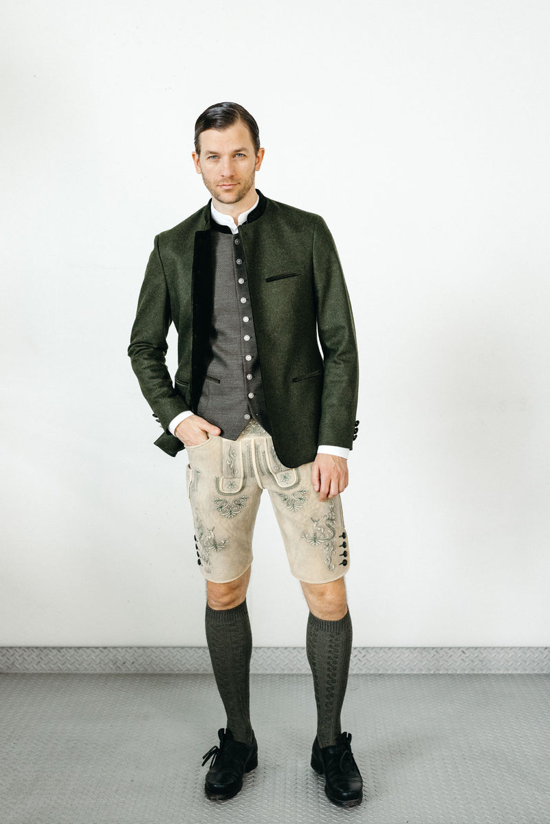 Dunkelgrüner Trachtenjanker mit grauer Weste, weißem Trachtenhemd und heller Hirschlederhose im modernen Trachtenlook.