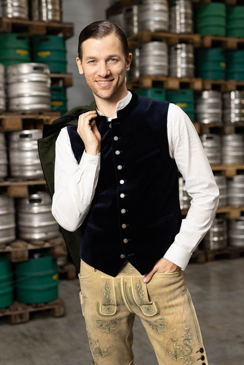 Navyblaue Samtweste mit weißem Trachtenhemd und heller Hirschlederhose im eleganten Trachtenlook.