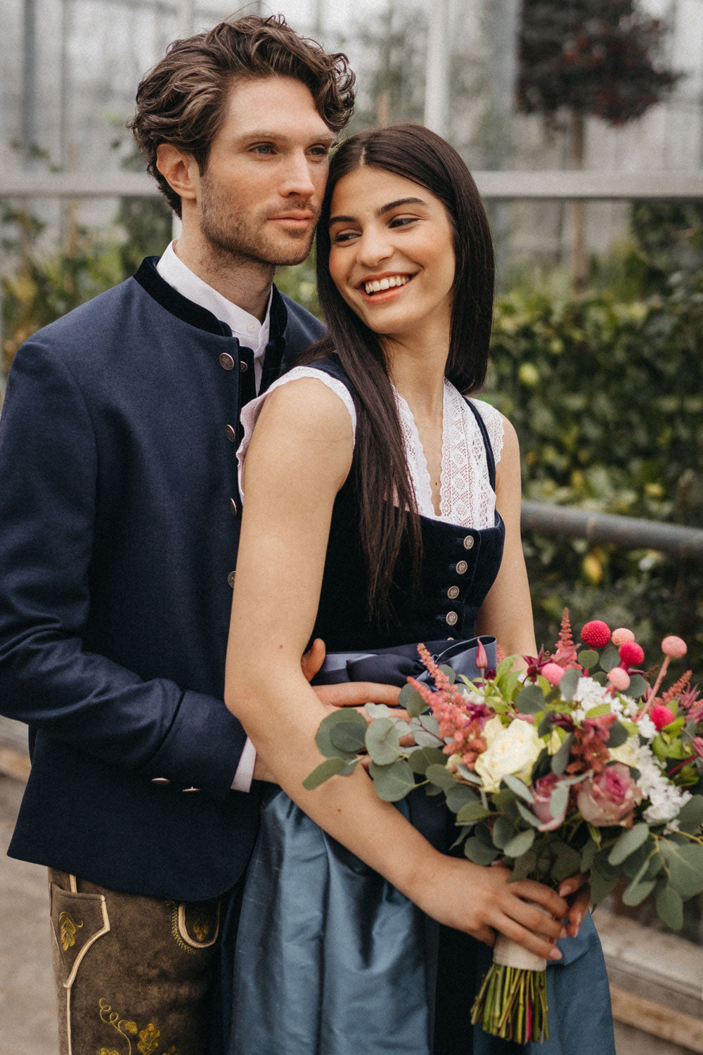 Brautpaar in moderner Tracht mit Samtdirndl und Trachtenjanker, festlicher Hochzeitslook von Amsel Fashion.