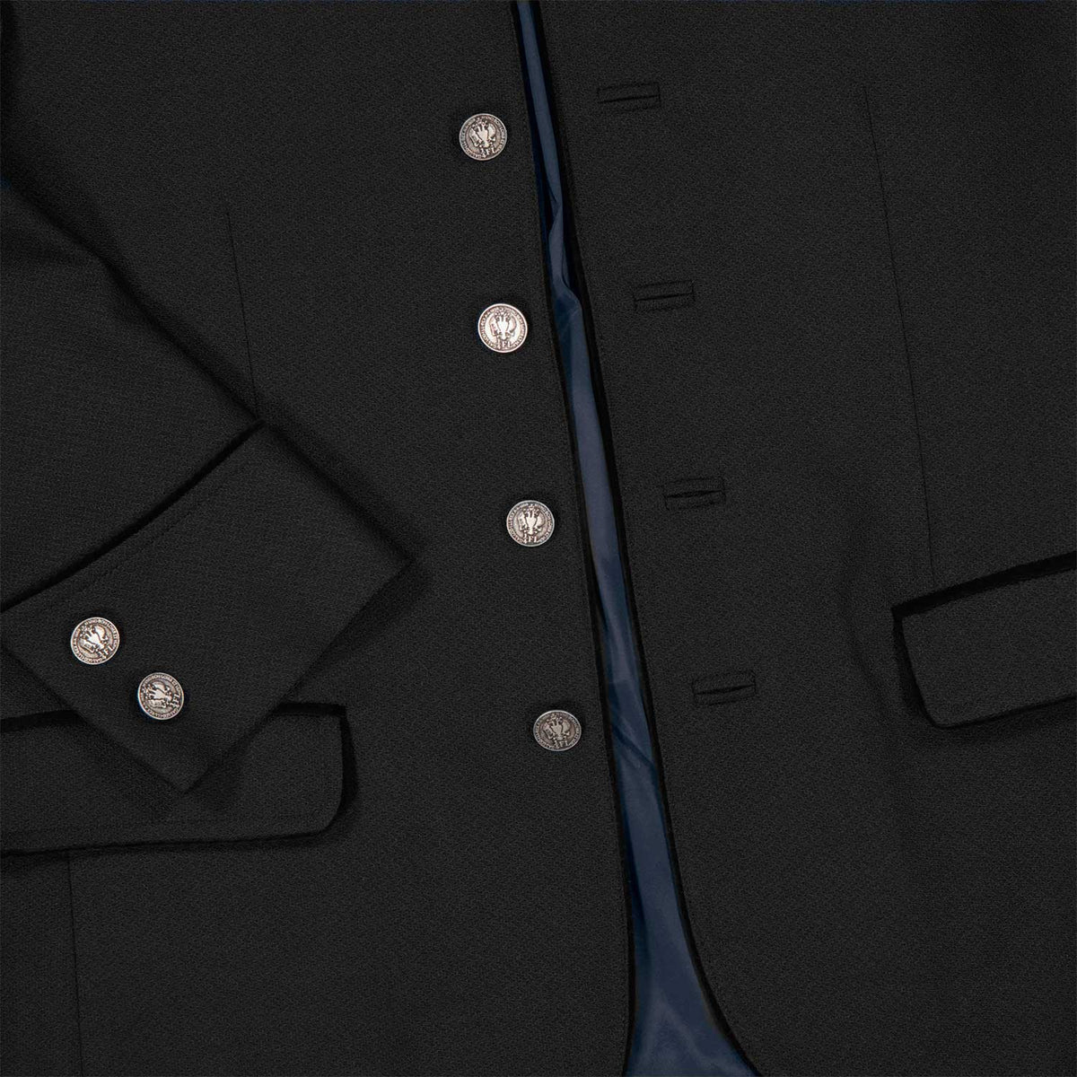 Detailaufnahme eines schwarzen Amsel Jankers mit silbernen Münzknöpfen, strukturierter Stoffoberfläche und dunkelblauem Innenfutter