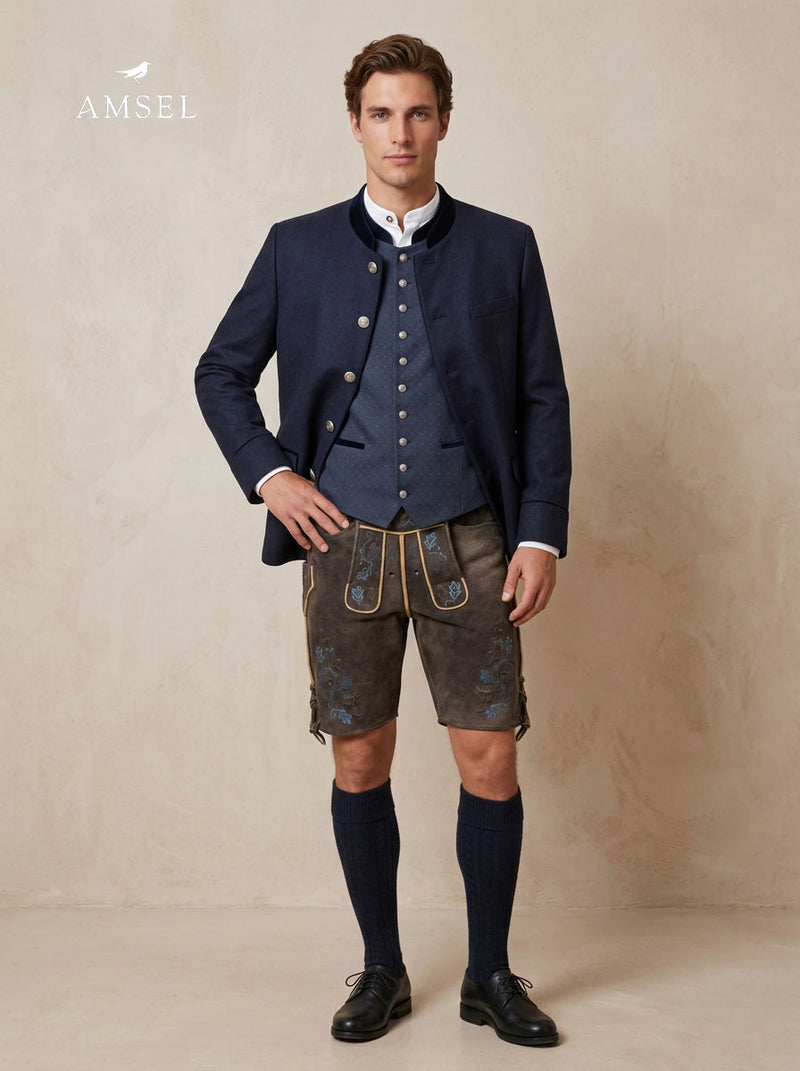Eleganter Trachtenlook mit dunkelblauem Janker, gemusterter Trachtenweste und Hirschlederhose mit blauer Stickerei – stilvoll kombiniert für Wiesn, Hochzeiten und festliche Anlässe
